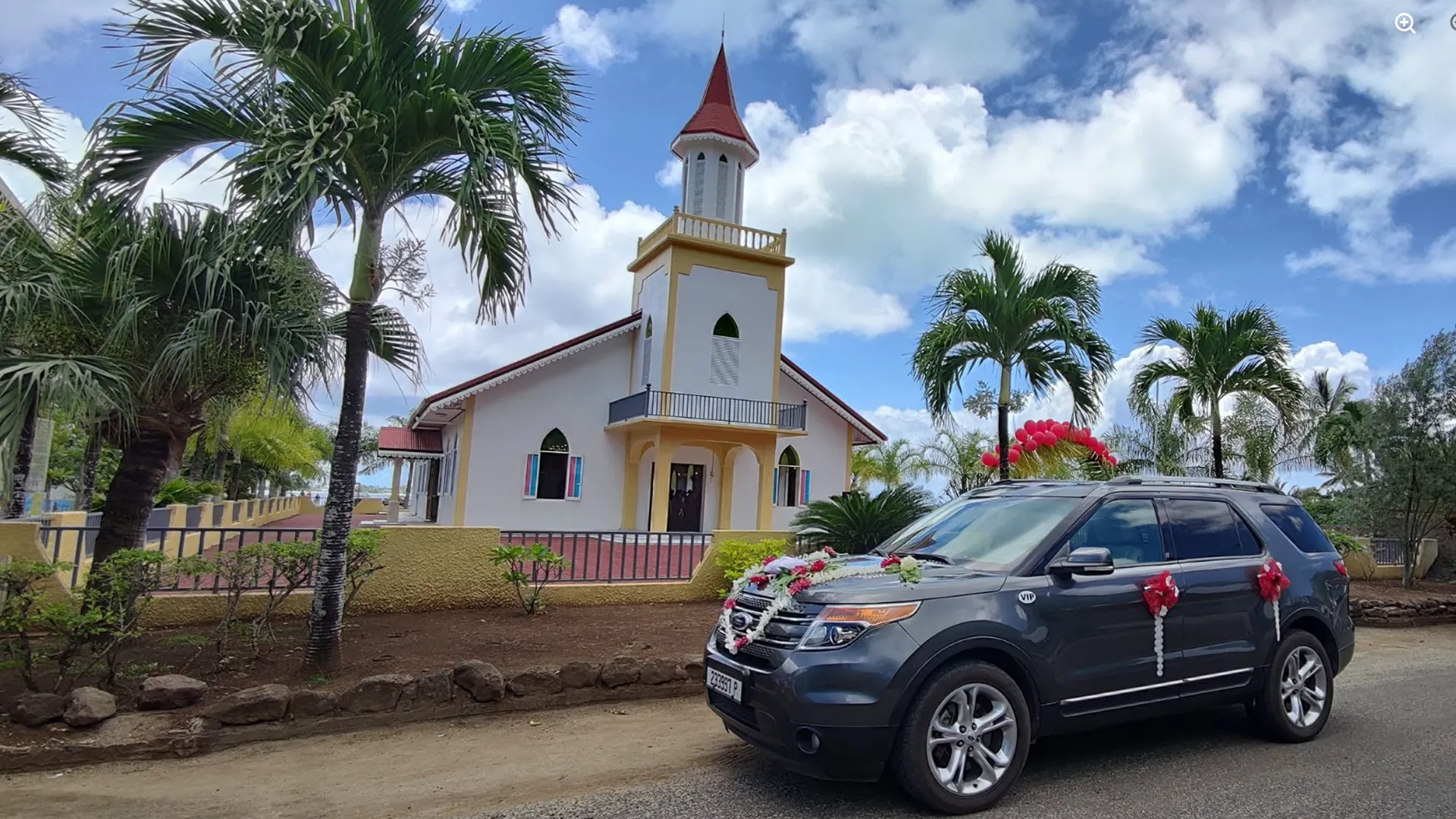 Historic white Protestant Church with tall steeple in Vaitape center, Bora Bora